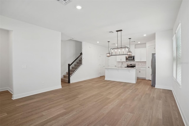 16484 Silver Brook Way, Winter Garden, FL 34787 - unfurnished living room with stairway, light wood-style floors, a sink, recessed lighting, and baseboards