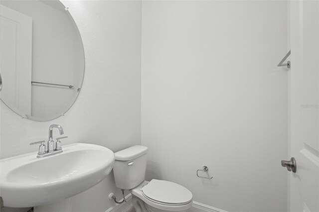 16484 Silver Brook Way, Winter Garden, FL 34787 - half bathroom featuring a sink, toilet, and baseboards