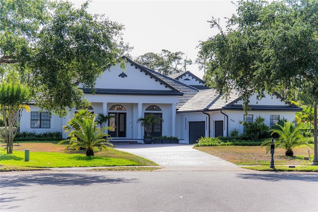 6550 Cartmel Ln, Windermere, FL 34786 - greek revival inspired property featuring a garage, stucco siding, a front lawn, and driveway