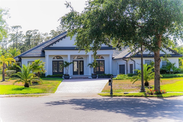 6550 Cartmel Ln, Windermere, FL 34786 - view of front of property with a tiled roof, stucco siding, french doors, and decorative driveway