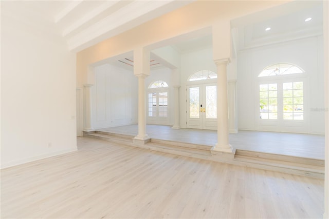 6550 Cartmel Ln, Windermere, FL 34786 - unfurnished living room with light wood-style floors, a high ceiling, french doors, and ornate columns
