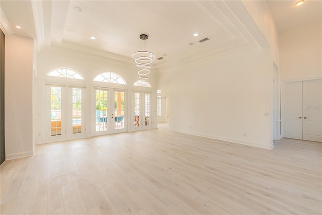 6550 Cartmel Ln, Windermere, FL 34786 - unfurnished living room featuring light wood-type flooring, baseboards, french doors, and a towering ceiling