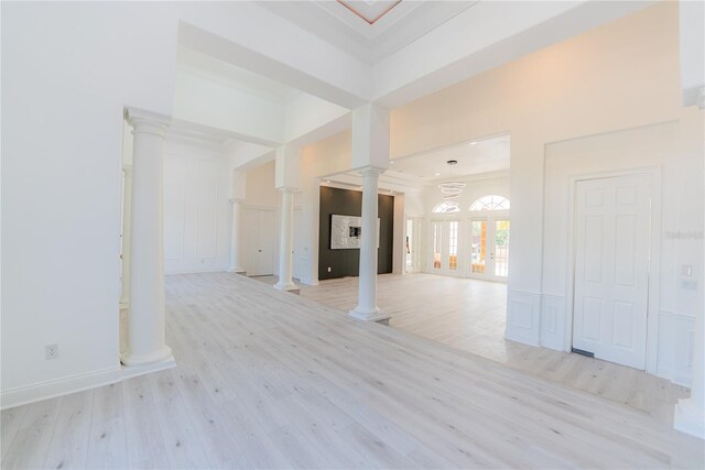 6550 Cartmel Ln, Windermere, FL 34786 - unfurnished living room with crown molding, light wood-style flooring, a decorative wall, and ornate columns