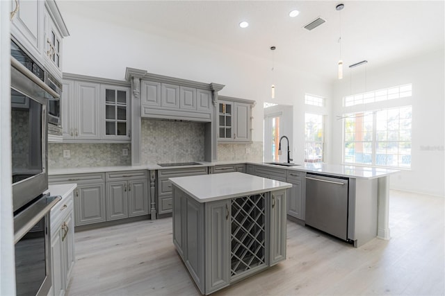6550 Cartmel Ln, Windermere, FL 34786 - kitchen with a peninsula, light wood-style flooring, a sink, stainless steel appliances, and gray cabinets