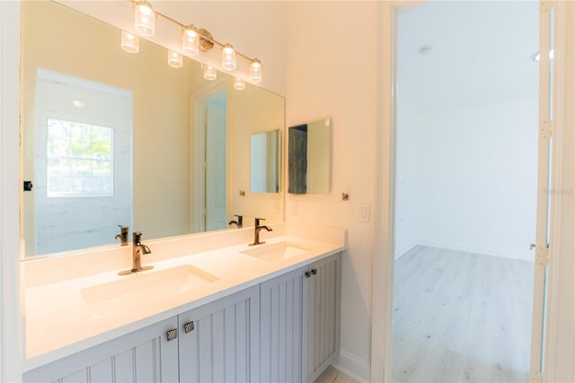 6550 Cartmel Ln, Windermere, FL 34786 - bathroom featuring baseboards, double vanity, a sink, and wood finished floors