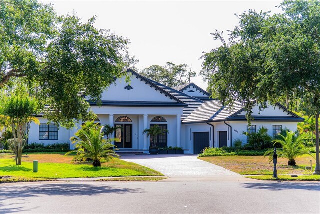 6550 Cartmel Ln, Windermere, FL 34786 - neoclassical / greek revival house with a front lawn, driveway, stucco siding, and a garage