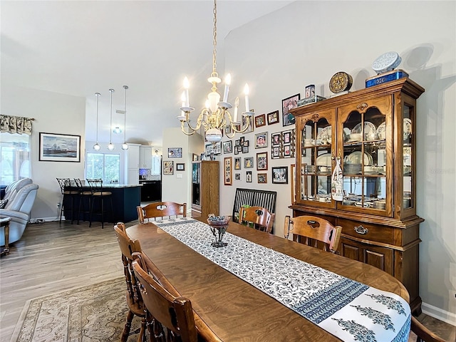 5060 NW 26th St, Ocala, FL 34482 - dining area with baseboards, high vaulted ceiling, light wood-type flooring, and an inviting chandelier