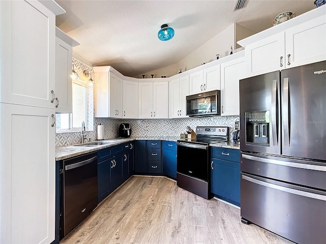 5060 NW 26th St, Ocala, FL 34482 - kitchen with tasteful backsplash, blue cabinetry, appliances with stainless steel finishes, a sink, and lofted ceiling