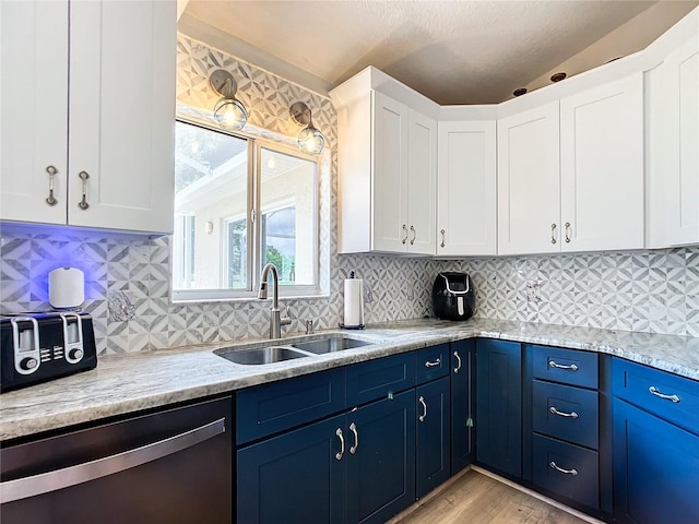 5060 NW 26th St, Ocala, FL 34482 - kitchen featuring stainless steel dishwasher, white cabinets, blue cabinetry, and a sink