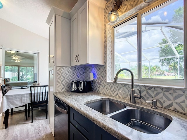 5060 NW 26th St, Ocala, FL 34482 - kitchen with ceiling fan, light stone countertops, vaulted ceiling, dishwasher, and a sink