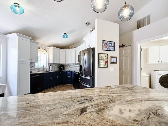5060 NW 26th St, Ocala, FL 34482 - kitchen with white cabinets, stainless steel refrigerator with ice dispenser, black dishwasher, vaulted ceiling, and light stone countertops