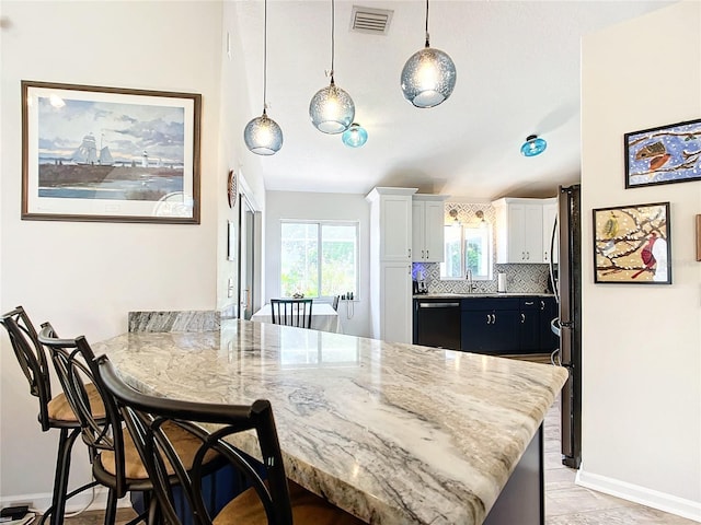 5060 NW 26th St, Ocala, FL 34482 - kitchen with tasteful backsplash, visible vents, dishwasher, a peninsula, and a breakfast bar area