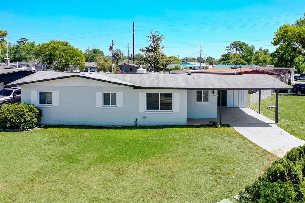 10900 Abigail St, Orlando, FL 32825 - rear view of house featuring a carport, a yard, and concrete driveway