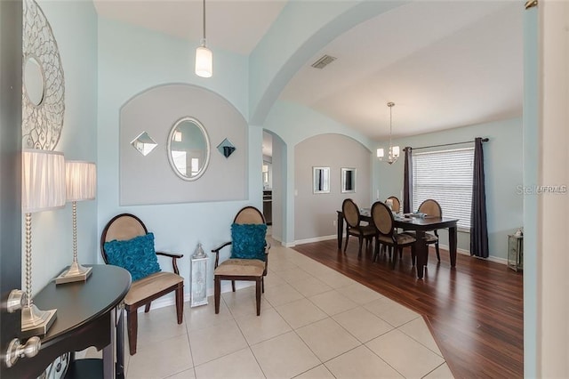 sitting room featuring visible vents, a chandelier, baseboards, arched walkways, and tile patterned floors