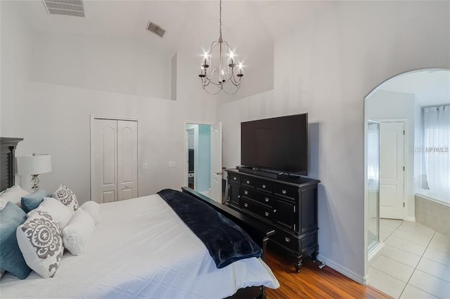 bedroom with a notable chandelier, a closet, visible vents, and high vaulted ceiling