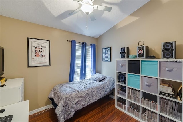 bedroom featuring wood finished floors, ceiling fan, vaulted ceiling, and baseboards