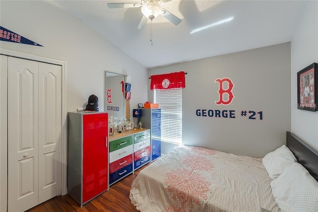 bedroom with ceiling fan, dark wood-style floors, vaulted ceiling, and a closet