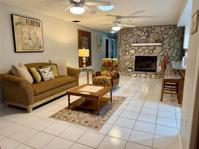 3652 Oak Grove Dr, Sarasota, FL 34243 - living room with ceiling fan, a textured ceiling, light tile patterned floors, and a fireplace