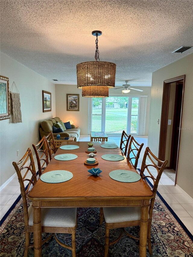 3652 Oak Grove Dr, Sarasota, FL 34243 - dining room with light tile patterned flooring, a textured ceiling, baseboards, and a ceiling fan