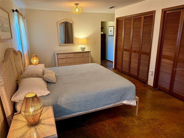 3652 Oak Grove Dr, Sarasota, FL 34243 - bedroom featuring two closets and a textured ceiling