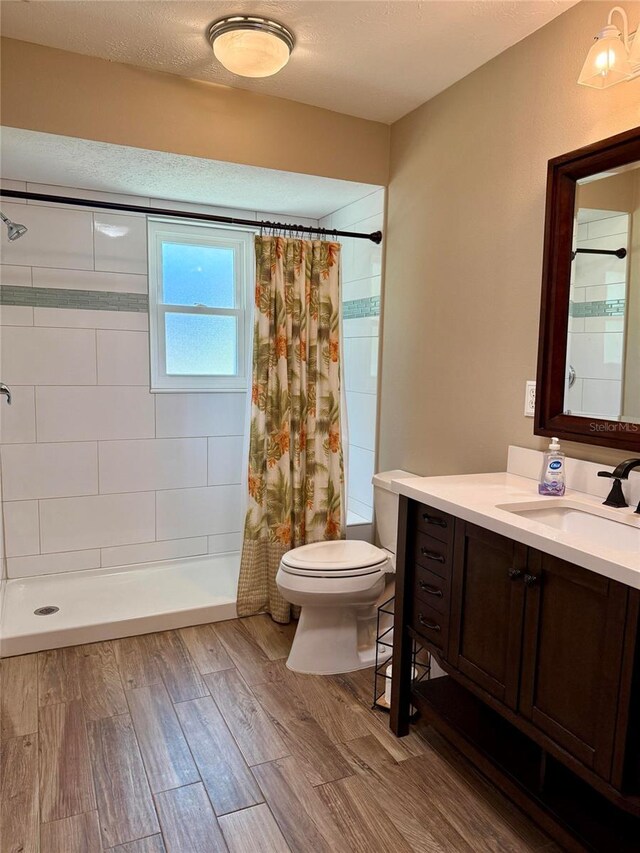 3652 Oak Grove Dr, Sarasota, FL 34243 - full bath featuring toilet, vanity, tiled shower, and wood finished floors