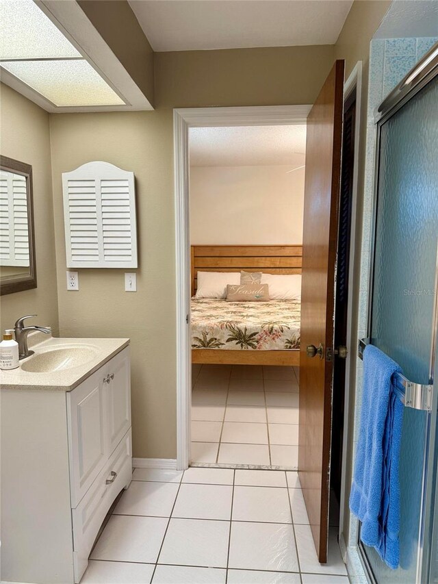 3652 Oak Grove Dr, Sarasota, FL 34243 - bathroom featuring vanity, tile patterned flooring, ensuite bathroom, baseboards, and a shower with shower door