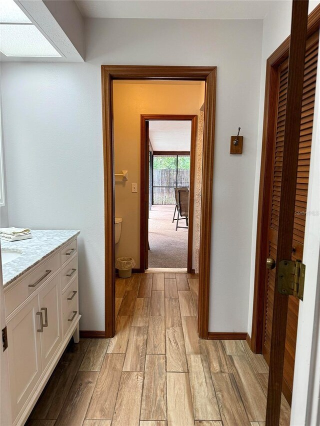 3652 Oak Grove Dr, Sarasota, FL 34243 - bathroom featuring wood finished floors, vanity, baseboards, and toilet