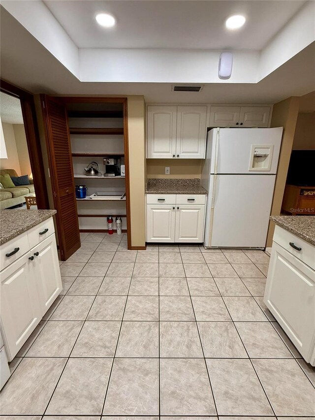 3652 Oak Grove Dr, Sarasota, FL 34243 - kitchen featuring white refrigerator with ice dispenser, white cabinetry, and light stone countertops