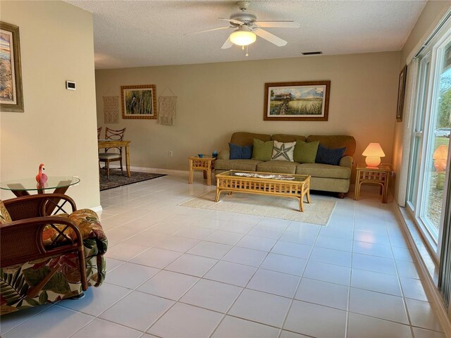 3652 Oak Grove Dr, Sarasota, FL 34243 - living room featuring healthy amount of natural light, a textured ceiling, a ceiling fan, and light tile patterned floors