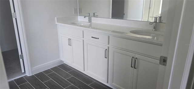 bathroom with double vanity, a sink, and wood tiled floor