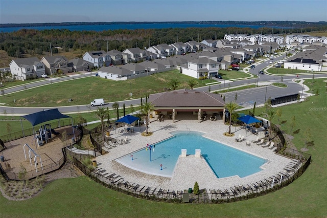 community pool featuring fence, a patio, and a residential view