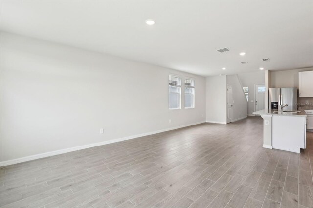 2320 E Newsome Rd, Plant City, FL 33565 - unfurnished living room featuring baseboards, light wood-style flooring, visible vents, and recessed lighting
