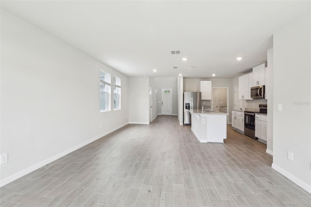 2320 E Newsome Rd, Plant City, FL 33565 - kitchen with stainless steel appliances, a center island with sink, open floor plan, visible vents, and white cabinetry