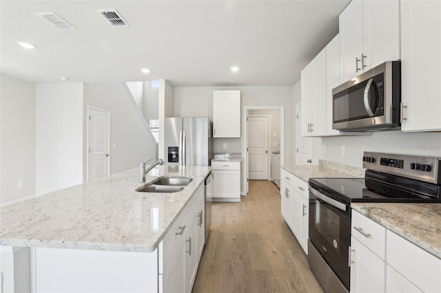 2320 E Newsome Rd, Plant City, FL 33565 - kitchen with a sink, a kitchen island with sink, light wood finished floors, appliances with stainless steel finishes, and visible vents