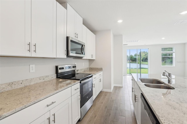 2320 E Newsome Rd, Plant City, FL 33565 - kitchen featuring a sink, light wood finished floors, baseboards, appliances with stainless steel finishes, and recessed lighting