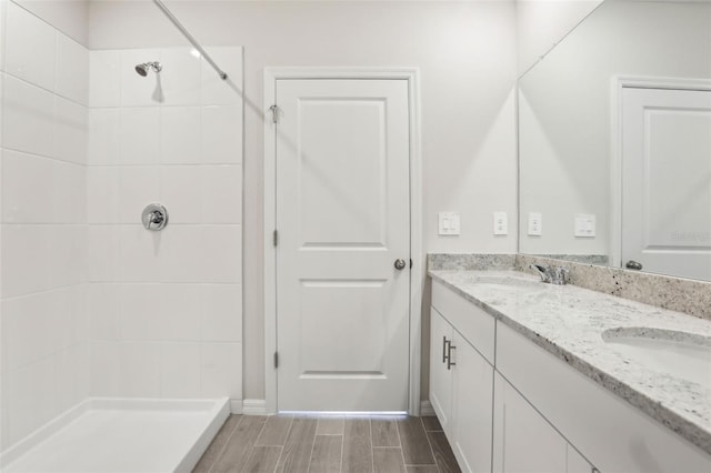 2320 E Newsome Rd, Plant City, FL 33565 - full bathroom with a tile shower, double vanity, wood finish floors, and a sink