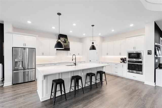 14749 Walcott Ave, Orlando, FL 32827 - kitchen with a sink, white cabinets, an island with sink, backsplash, and appliances with stainless steel finishes