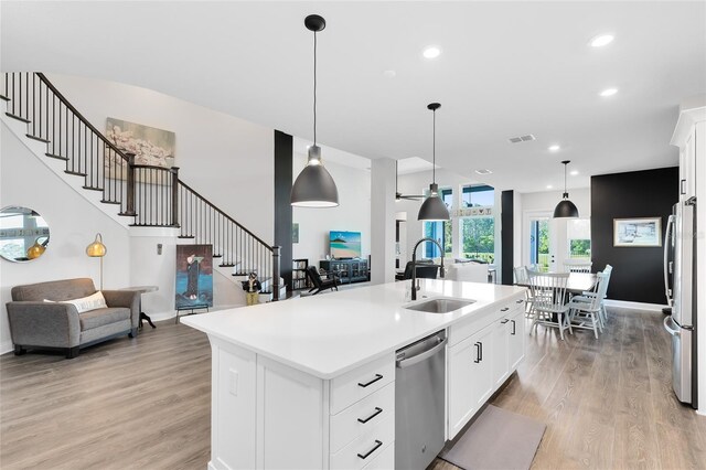 14749 Walcott Ave, Orlando, FL 32827 - kitchen with light wood-style floors, appliances with stainless steel finishes, light countertops, a sink, and decorative light fixtures