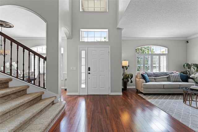 10033 Hart Branch Cir, Orlando, FL 32832 - entrance foyer with a textured ceiling, arched walkways, ornamental molding, wood-type flooring, and stairway
