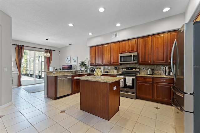 10033 Hart Branch Cir, Orlando, FL 32832 - kitchen with stainless steel appliances, a peninsula, tasteful backsplash, light stone counters, and a center island