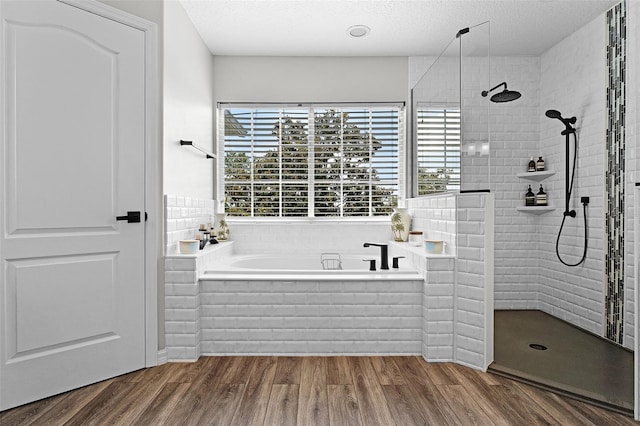 10033 Hart Branch Cir, Orlando, FL 32832 - full bath featuring a garden tub, plenty of natural light, a walk in shower, wood finished floors, and a textured ceiling
