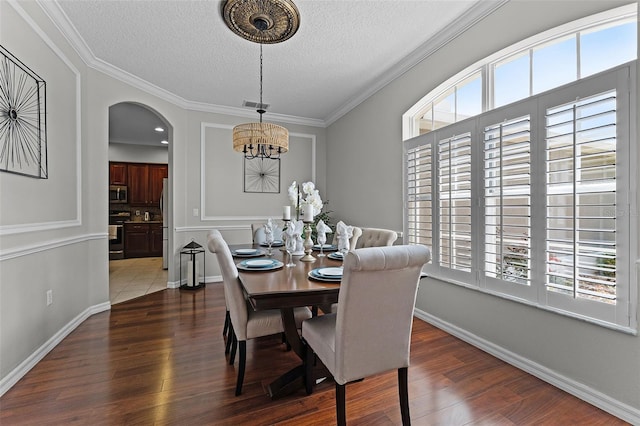 10033 Hart Branch Cir, Orlando, FL 32832 - dining room with a chandelier, a textured ceiling, dark wood finished floors, arched walkways, and baseboards