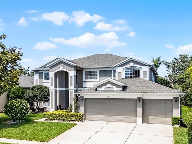 10033 Hart Branch Cir, Orlando, FL 32832 - view of front facade featuring stucco siding, a garage, concrete driveway, and a shingled roof