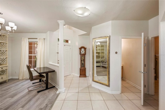 interior space featuring baseboards, a textured ceiling, and an inviting chandelier