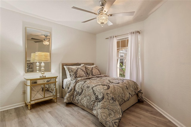 bedroom with baseboards, ceiling fan, and wood finished floors