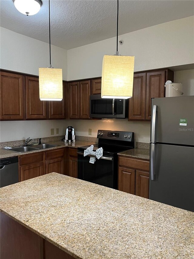 12539 Floridays Resort Dr Unit 208D, Orlando, FL 32821 - kitchen with decorative light fixtures, a sink, appliances with stainless steel finishes, a textured ceiling, and light stone counters