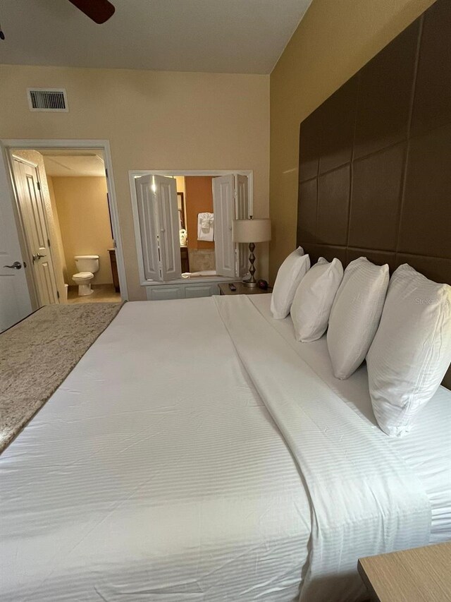 12539 Floridays Resort Dr Unit 208D, Orlando, FL 32821 - bedroom featuring ensuite bath, a ceiling fan, and visible vents