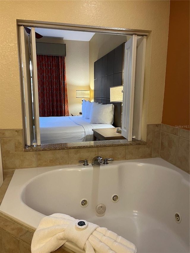 12539 Floridays Resort Dr Unit 208D, Orlando, FL 32821 - full bath featuring a textured wall and a whirlpool tub