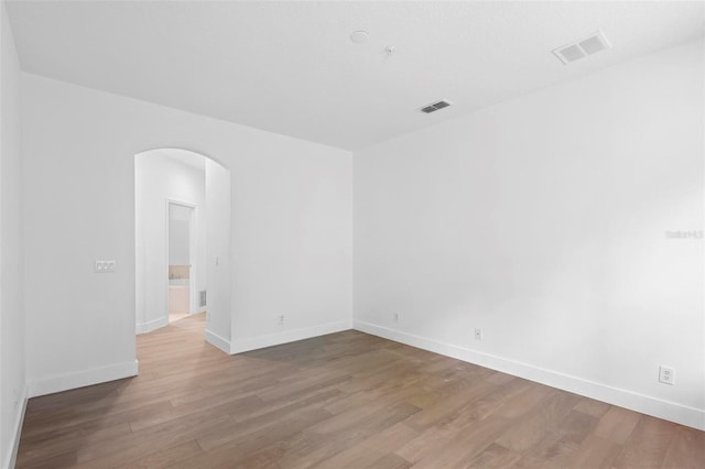 456 Harbor Winds Ct, Winter Springs, FL 32708 - spare room featuring arched walkways, visible vents, baseboards, and wood finished floors