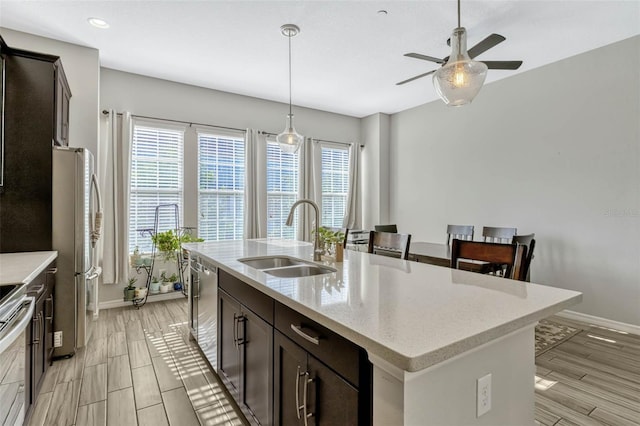 861 Taramundi Dr, Oviedo, FL 32765 - kitchen featuring stainless steel appliances, a ceiling fan, a sink, dark brown cabinetry, and baseboards